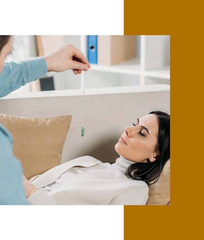 A person expertly guides a pendulum over a relaxed woman lying on a couch, seamlessly incorporating EFT techniques into the hypnosis therapy session.