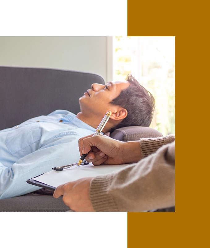 A person lies on a couch, engaged in EFT Therapy, while another person takes notes on a clipboard.