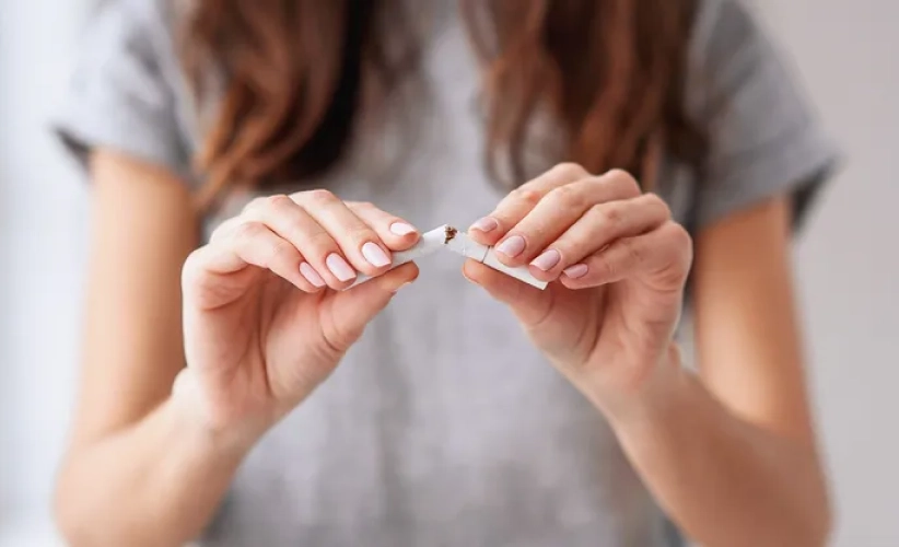 A person decisively snaps a cigarette in half, symbolizing their commitment to quitting smoking, potentially with the support of hypnosis therapy.